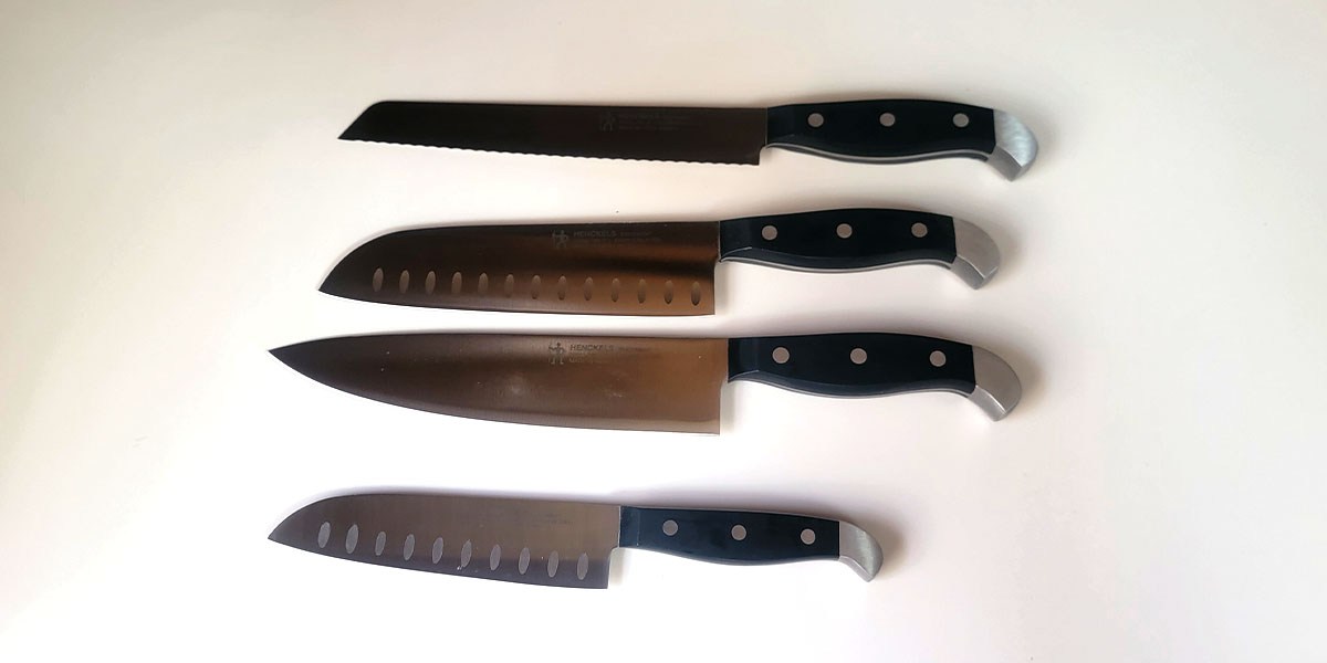 Four Henckels Premium Quality knives aith black handles displayed on countertop Four Henckels Premium Quality knives aith black handles displayed on countertop