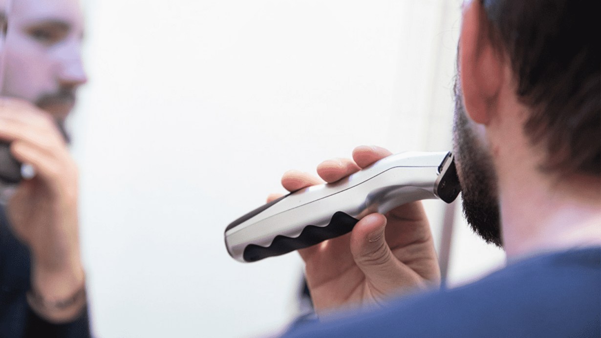 A young man is using the hair trimmer A young man is using the hair trimmer
