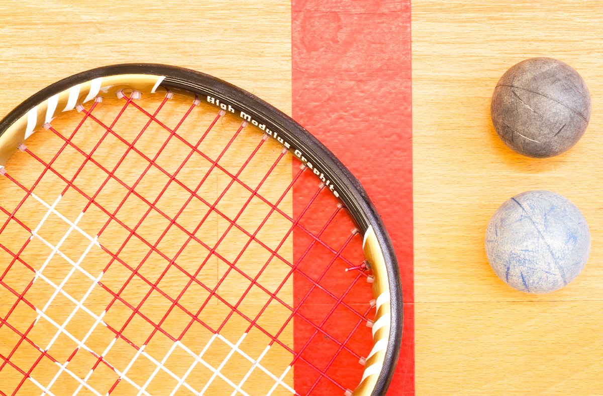 I1 A racquetball racquet on the floor next to two racquetballs